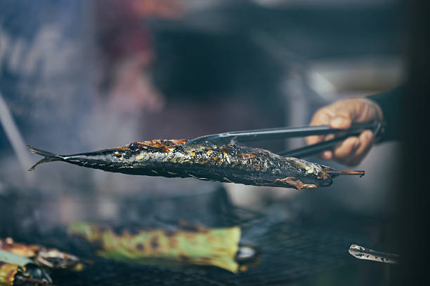 Unrecognizable Thai person is preparing fish on grill.Phuket Island - Thailand.