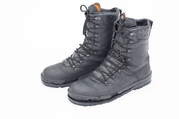 istock Worn and torn military boots resting on a snowy surface during a cold winter day 2251360980