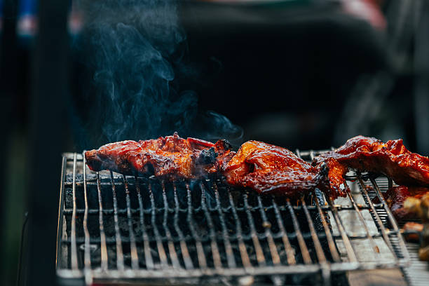 Chicken meats are cooking on barbecue grill.