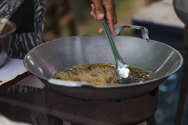 Asian street food market.Preparing Asian style deep fried chicken leg in cooking pan.Phuket Island - Thailand.