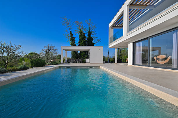 istock Modern luxury villa with pool, terrace, and minimalist architecture on a sunny day. Clean lines, large windows, and outdoor living spaces create a stylish contemporary home setting 2251363549