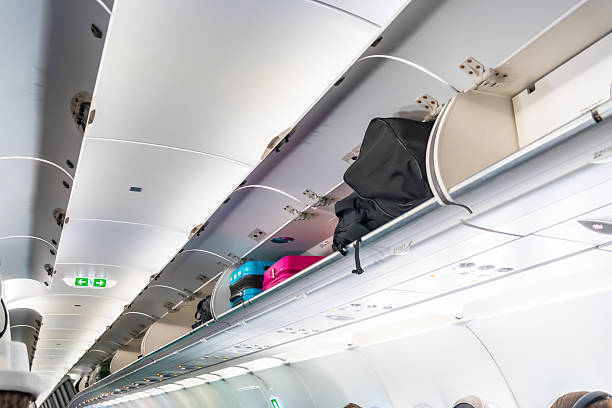 istock Carry-on luggage stored in overhead compartment inside airplane cabin 2251364505