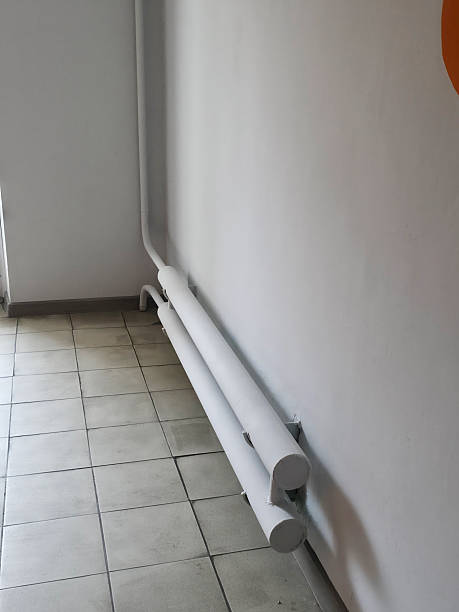 istock White pipes run along light wall on tiled floor 2251364594