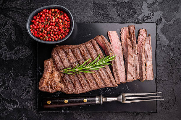 istock Grilled medium beef Rump steak on marble board. black background. top view 2251365020