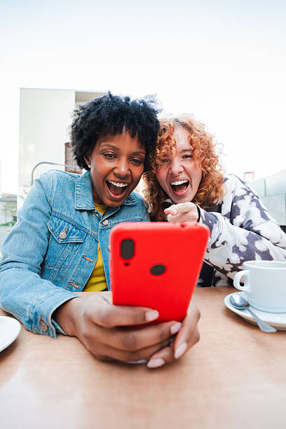 istock Two excited young women joyfully sharing a delightful moment while using a smartphone together 2251366426