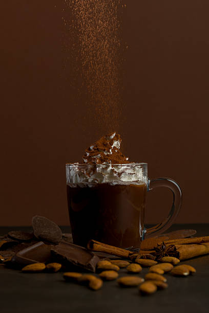 istock Hot drink with whipped cream and chocolate placed on a dark table surrounded by various ingredients in a warm setting 2251373491