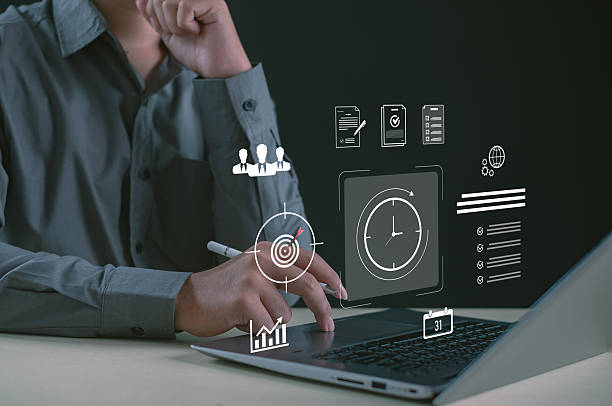 istock Professional using laptop with virtual productivity icons, task management graphics, time tracking, and business planning elements, illustrating modern workflow optimization and digital organization. 2251374753