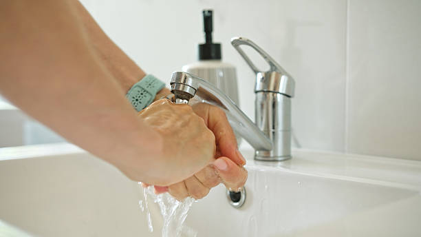 istock Woman Washing Hands Over Sink 2251376449