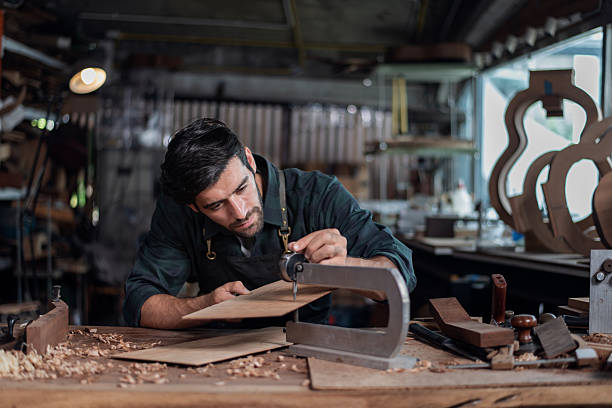 istock Luthier making top of guitar using traditional tools in workroom with manual tools. 2251377840