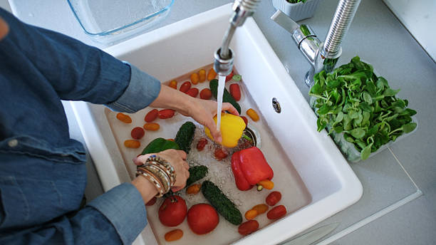 istock Woman Washing Bright Vegetables Over Sink 2251377853