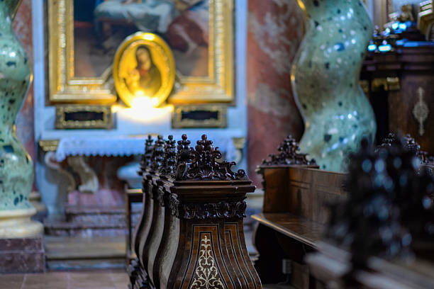 Vienna, Austria - 7 February 2025: Richly decorated chapel with carved pews, marble columns, and Madonna painting.