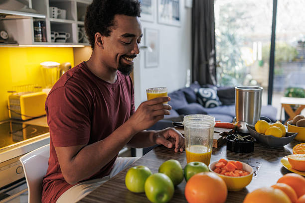 istock Young man making fresh juice in modern home kitchen 2251378341
