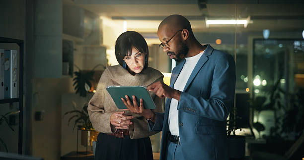 istock Tablet, conversation and business people in office for report, collaboration and feedback. Tech, drafting proposal and research with team for proofreading, review and editing publication at night 2251378692