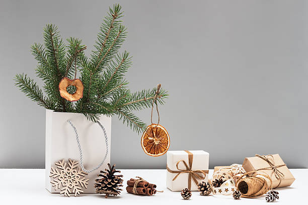 istock Fir branches decorated with dried orange slices and Christmas gift boxes in craft packaging. Wooden snowflake. Natural materials and textures in New Year's decor, DIY gifts. Boxing Day. 2251379894