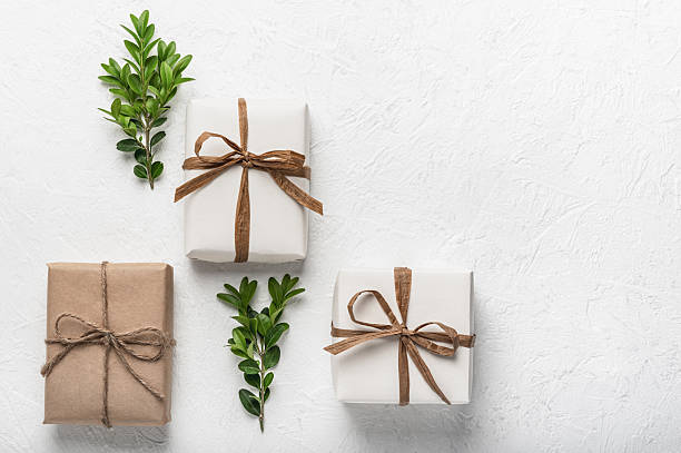 istock Three craft gift boxes on a white background and green boxwood branches. The concept of holidays and DIY gifts. Postcard, mock-up. 2251379949