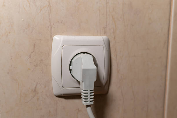 A close-up shot of a white electrical plug inserted into a wall socket, highlighting home electricity, safety, and everyday household power usage. Clean and simple composition suitable for illustrating energy or technology concepts. High quality photo