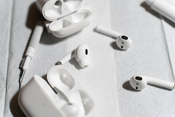 istock A set of wireless earbuds, charging cases, and cleaning tools laid out on a white surface during a detailed cleaning process. The image highlights tech maintenance, hygiene, and device care. 2251384708