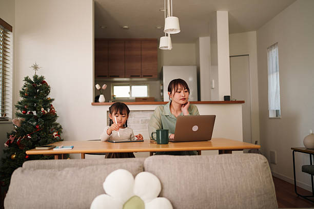 istock Mother working on laptop while child draws on tablet at home 2251385037