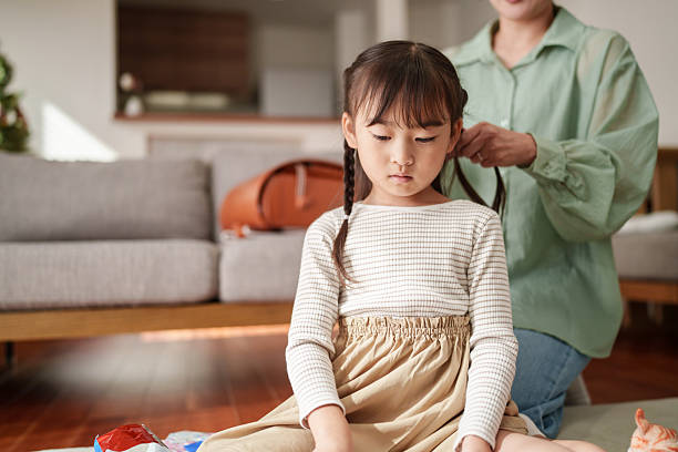 istock Mother Gently Braiding Her Daughter’s Hair at Home 2251386227