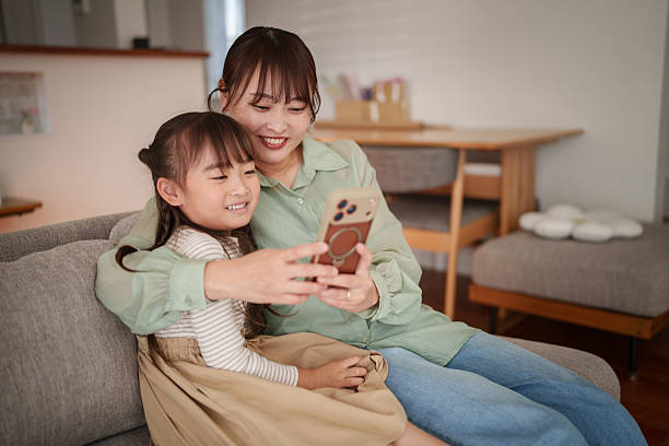 istock Happy mother and child using smartphone together at home 2251386525