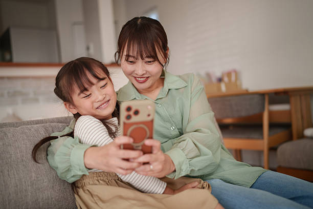 istock Happy mother and child using smartphone together at home 2251386530