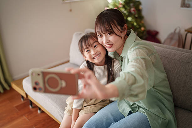 istock Happy mother and child using smartphone together at home 2251386576