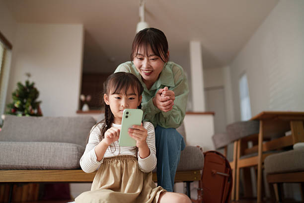 istock Mother helping her child use a smartphone at home 2251386740