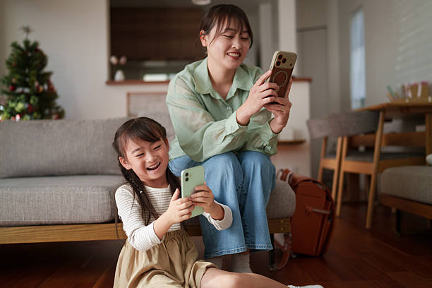 Mother helping her child use a smartphone at home