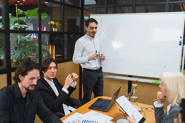 istock Teamwork brainstorm. Coworkers cooperating working together at office meeting. Colleagues discussing project ideas. Group of people in creative office discussing business. Young professional team. 2251399322