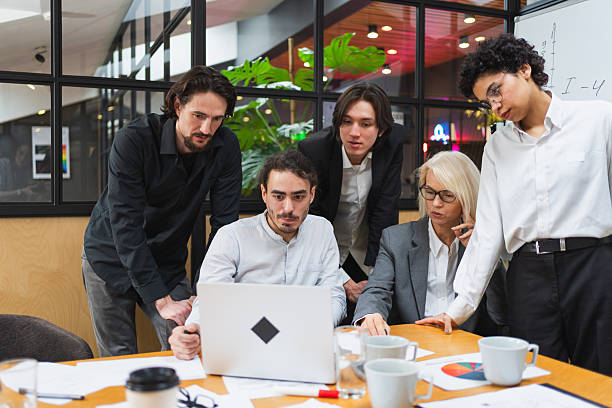 istock Teamwork brainstorm. Coworkers cooperating working together at office meeting. Colleagues discussing project ideas. Group of people in creative office discussing business. Young professional team. 2251400228