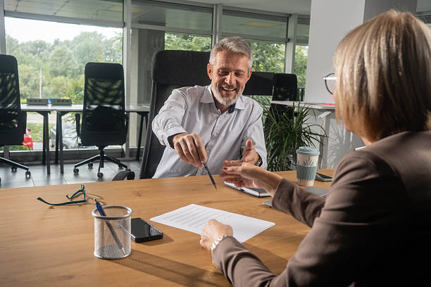 istock Happy insurance agent talking to his customer in the office. 2251402129