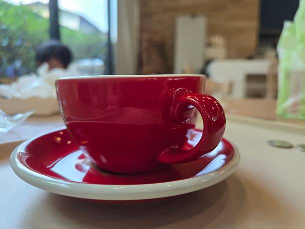 istock Bright Red Coffee Cup on White Saucer with Blurred Background 2251402215