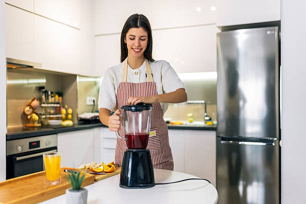 istock Young Woman Making Smoothie at Home 2251415002