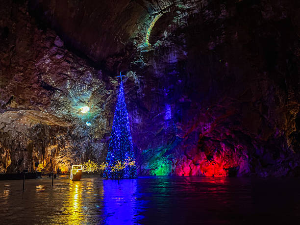 Postojna, Slovenia -19.12.2022-  Christmas Tree and Light Installation in an Illuminated Postojna Cave Interior