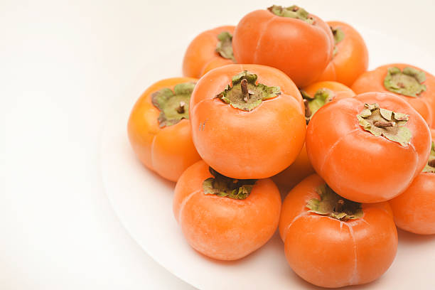 persimmon fruit. fresh persimmon fruit cut in half. Kaki plum fruit, Japanese persimmon, Diospyros kaki Lycopersicum