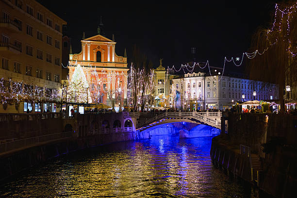 Brightly lit streets and festive decorations create a magical atmosphere in Ljubljana during the Christmas evening.