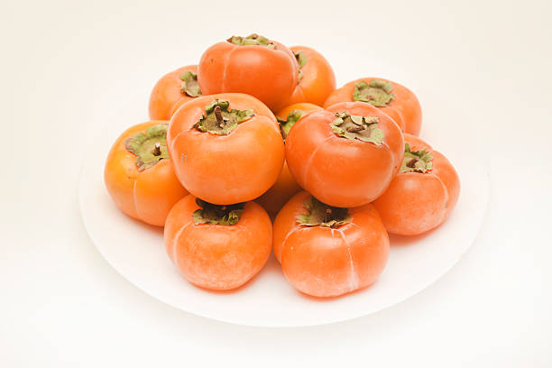 Orange persimmon fruits. Ripe persimmon on a plate.