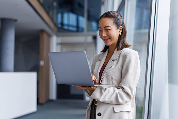 istock Asian businesswoman smiling using laptop in modern office 2251418924
