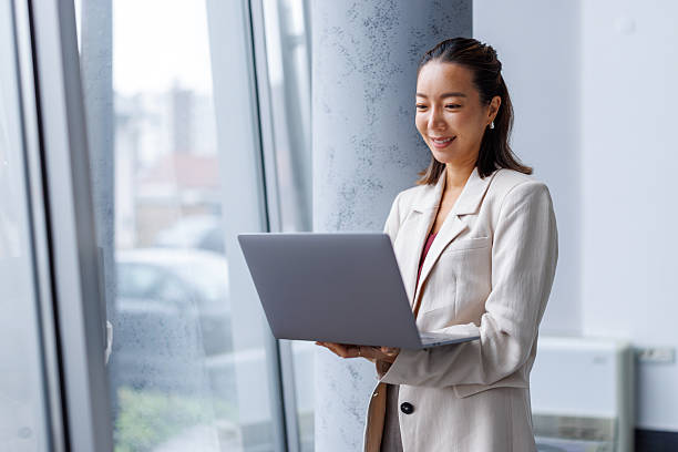istock Professional asian businesswoman smiling while working with laptop 2251419997