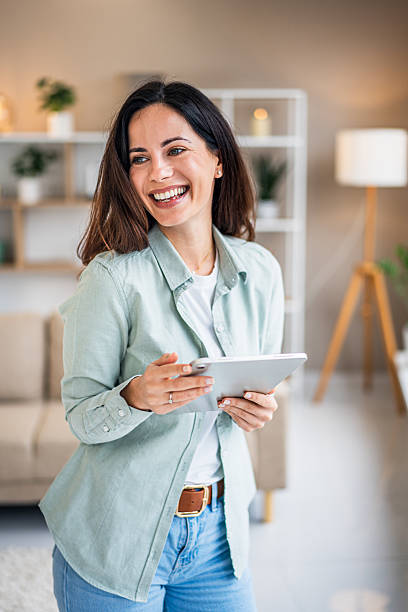 istock Happy woman using digital tablet enjoying technology at home 2251421386