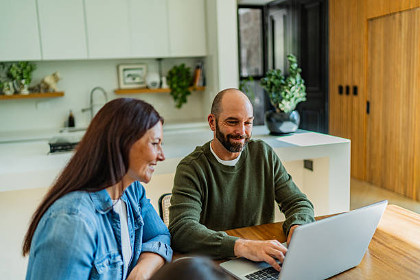 istock Couple talking and using laptop at home 2251422865