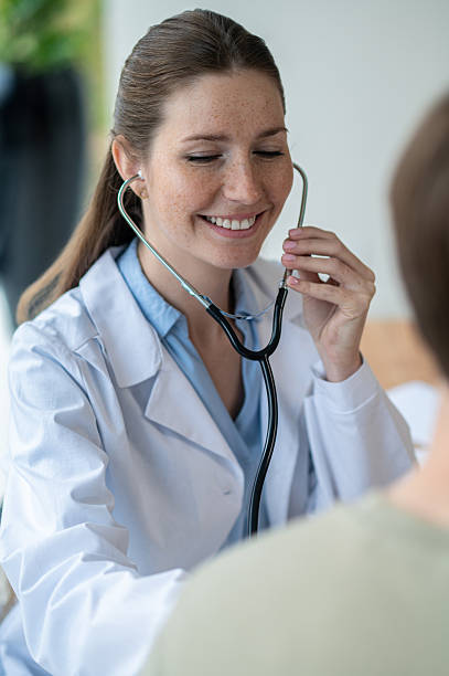 istock Smiling female young doctor in a lab coat with a stethoscope 2251423492
