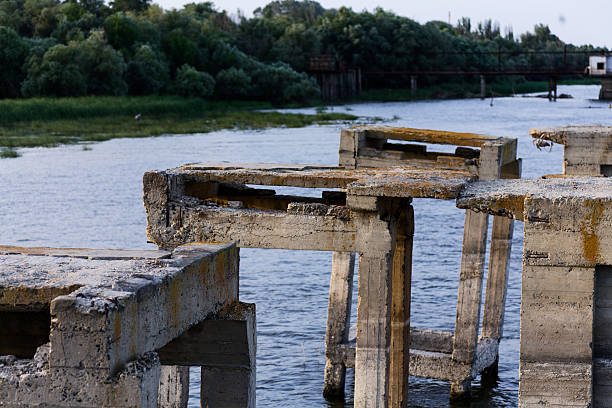 istock Abandoned Infrastructure: Rustic Bridge Decaying Over Calm River, Nature Reclaiming Worn Structure 2251424769