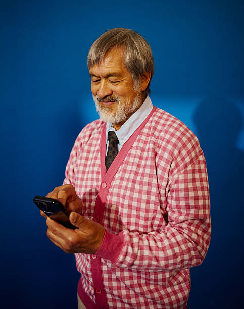 Cheerful senior man using a smartphone, feeling young at heart and connected