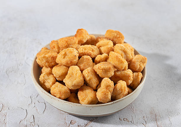 istock Crispy chicken popcorn in a ceramic bowl on white background. Fast food snack or appetizer. Close-up 2251430375