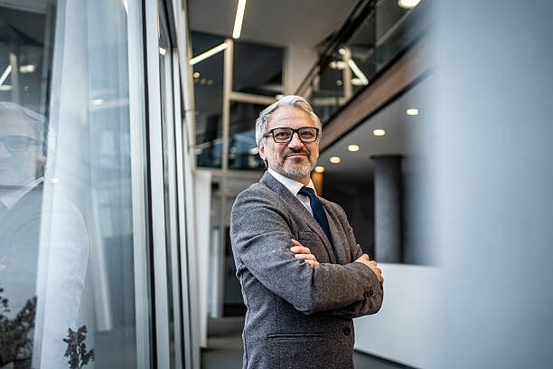 istock Confident mature businessman standing in modern office building 2251439627