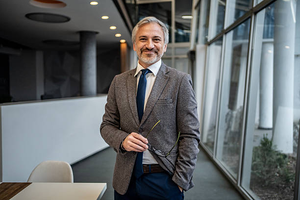 istock Mature confident businessman smiling in modern office interior 2251439644