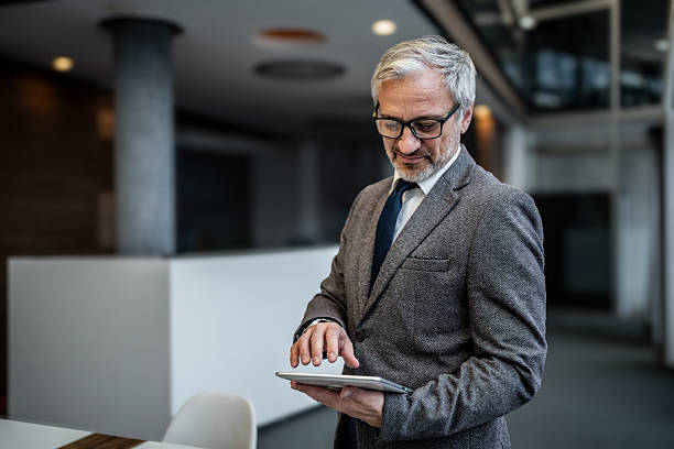 istock Mature businessman working with digital tablet in office 2251439672