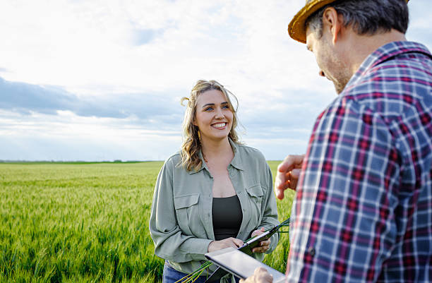 istock Two farmers standing in wheat field examining crop yield. 2251440870