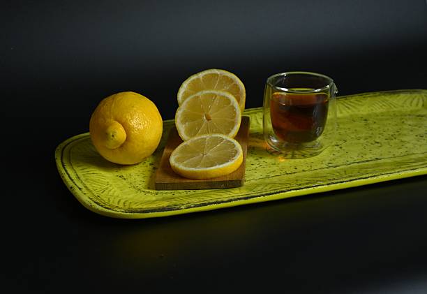istock Vibrant Still Life: Tea and Lemon Slices on a Yellow Ceramic Tray 2251440901